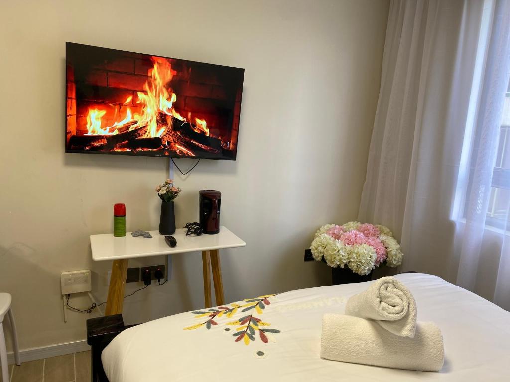 a room with a bed with a fireplace on the wall at Sure Stay Homes in Gatunga