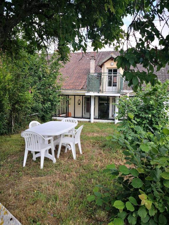 a white table and chairs in front of a house at Le logis des Fadettes in Saint-Martin-le-Mault