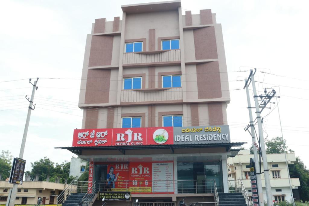 a tall building with a sign in front of it at Ideal Residency in Gulbarga