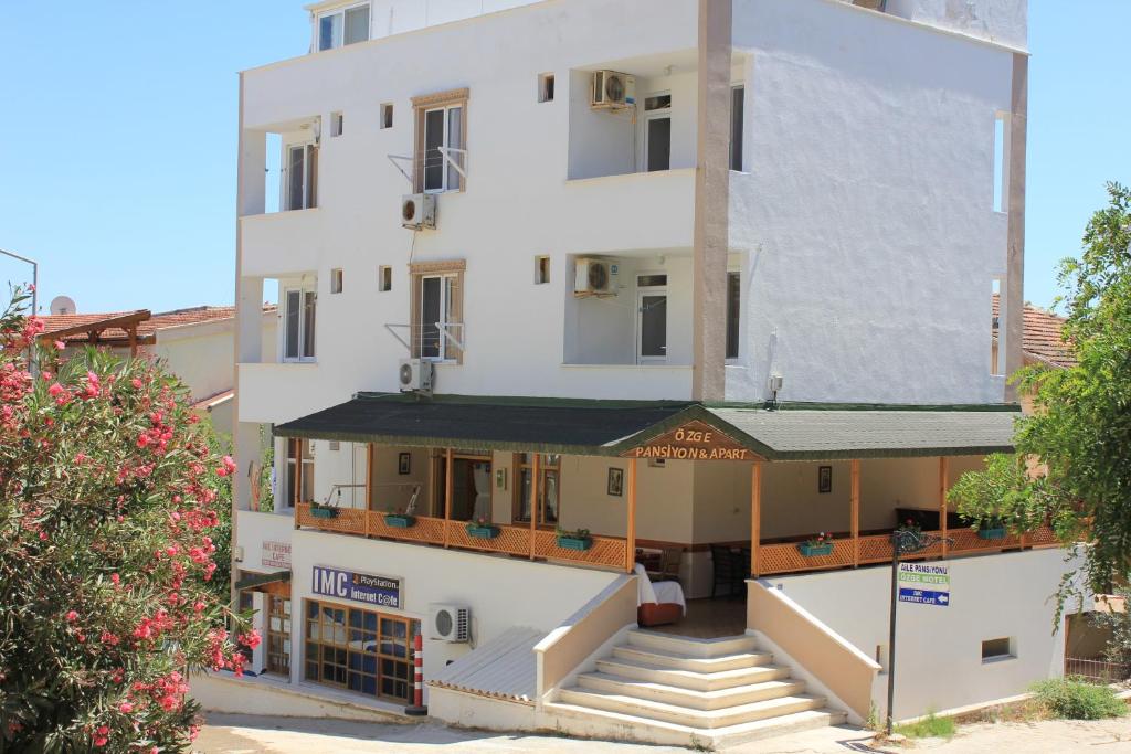 un gran edificio blanco con escaleras delante en Ozge Pansiyon en Didim
