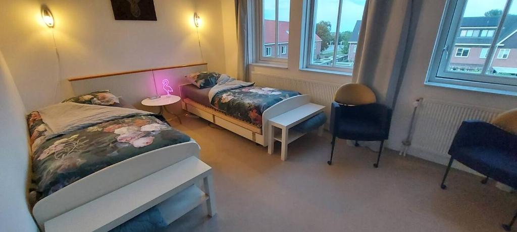a bedroom with two beds and a desk in it at Airbnb Meppel Centrum in Meppel