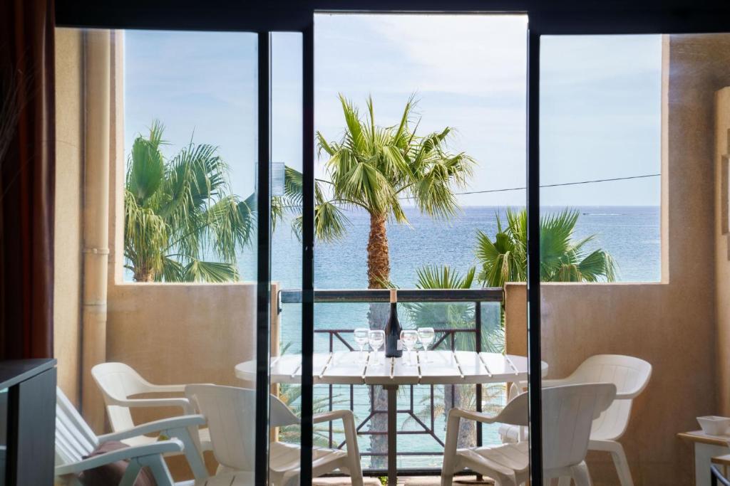 Un comedor con mesa y vista al mar. en Azuréa, vue mer avec ses 2 piscines, en Cannes