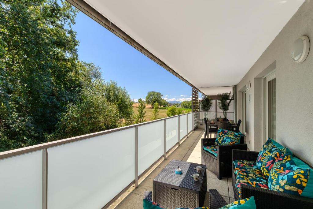 un balcon extérieur avec des canapés et une table dans l'établissement Pur horizon, à Annecy