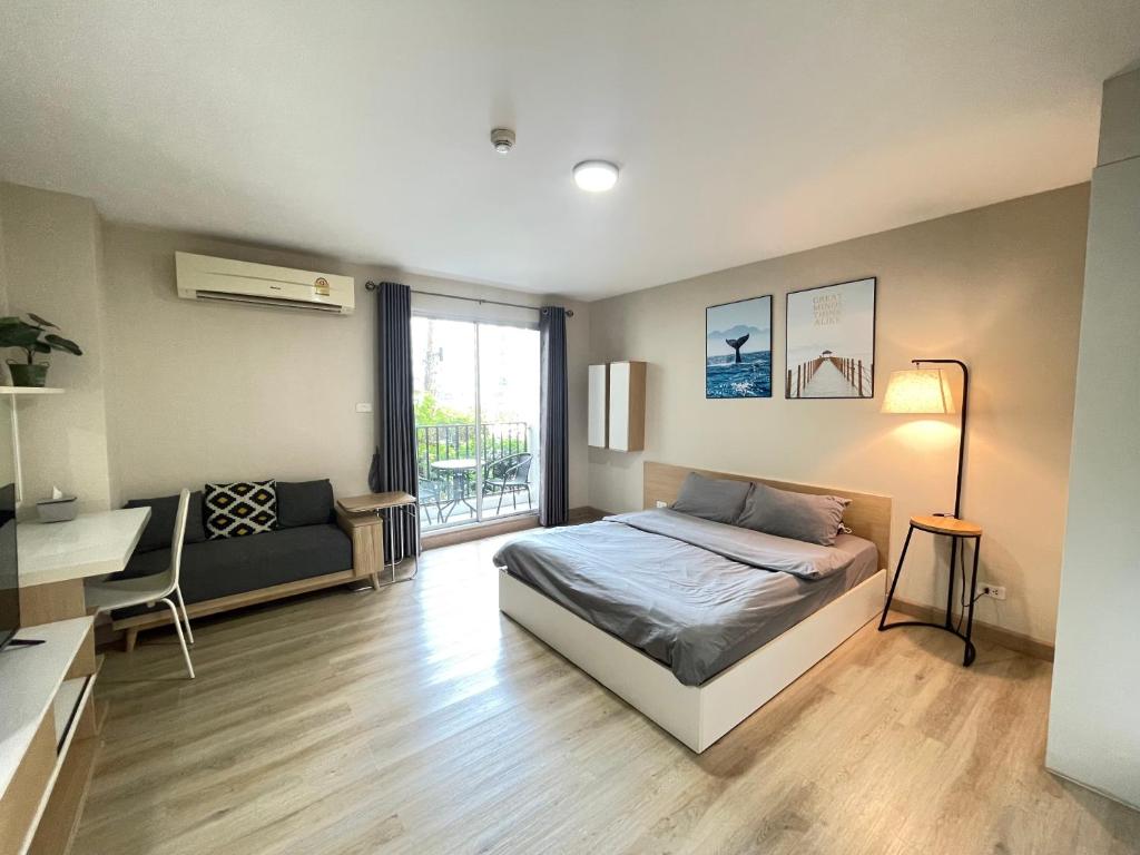 a bedroom with a bed and a desk and a window at Studio16 at Changwattana in Ban Bang Phang
