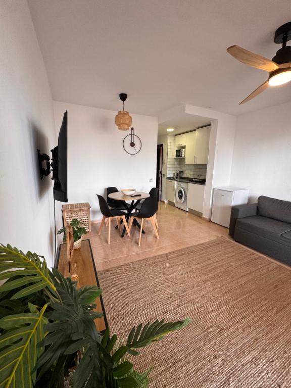 a living room with a table and a couch at Oasis Jaylota in Corralejo