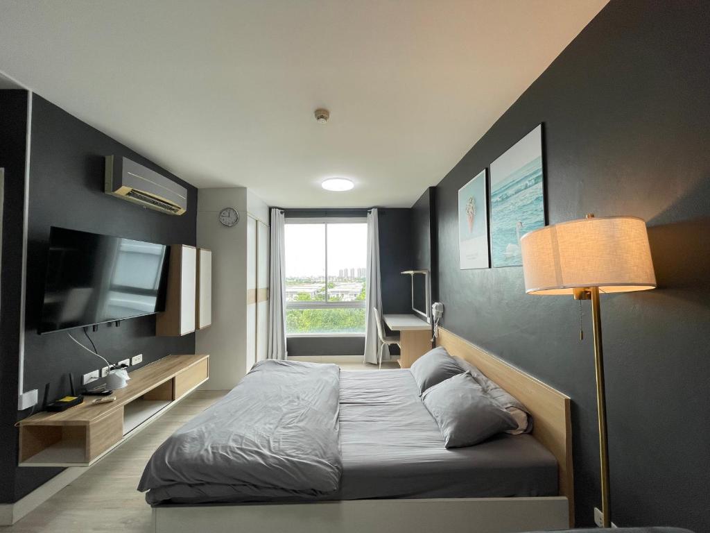 a small bedroom with a bed and a television at Studio123 at changwattana in Ban Bang Phang