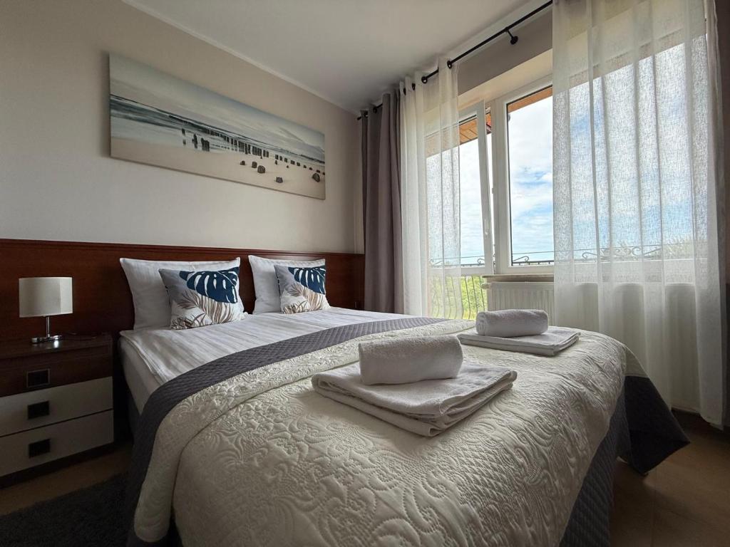 Un dormitorio con una cama grande con toallas. en Willa Ariadna, en Jastrzębia Góra