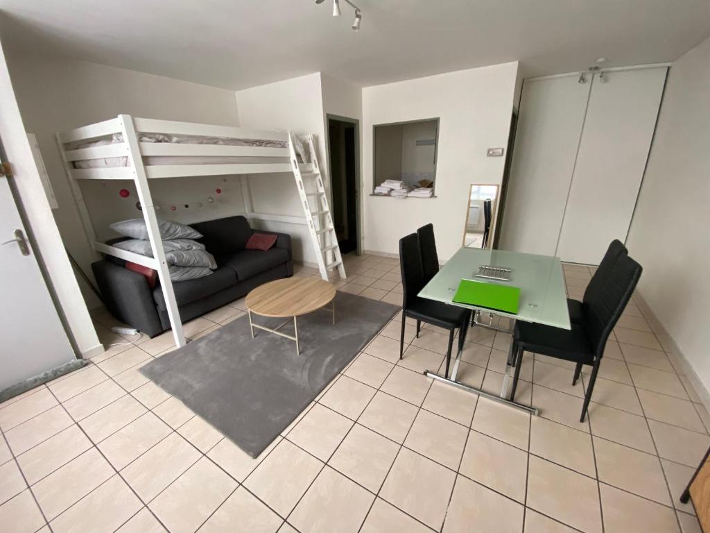 - un salon avec une table et des lits superposés dans l'établissement Studio près gare Amiens et centre, à Amiens