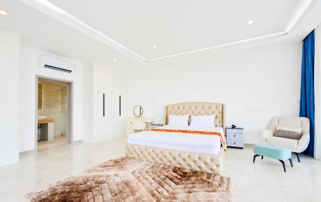 a bedroom with a large bed and a chair at Ocean skyline villa Bophut in Amphoe Koh Samui