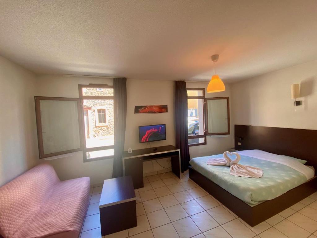 a bedroom with a bed and a chair and a tv at Studio Cité médiévale 250 m in Carcassonne