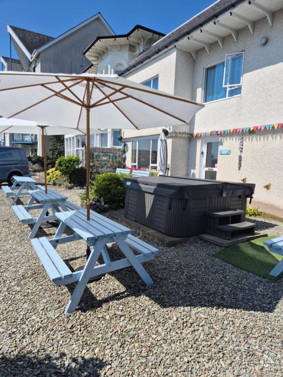 two picnic tables with an umbrella and a grill at Firthview House great for families with children pet friendly in Kirn