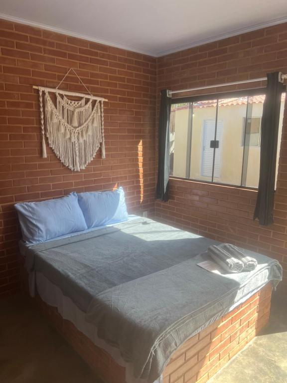 a brick bedroom with a bed in a brick wall at Flats Ribeiro in Alto Paraíso de Goiás