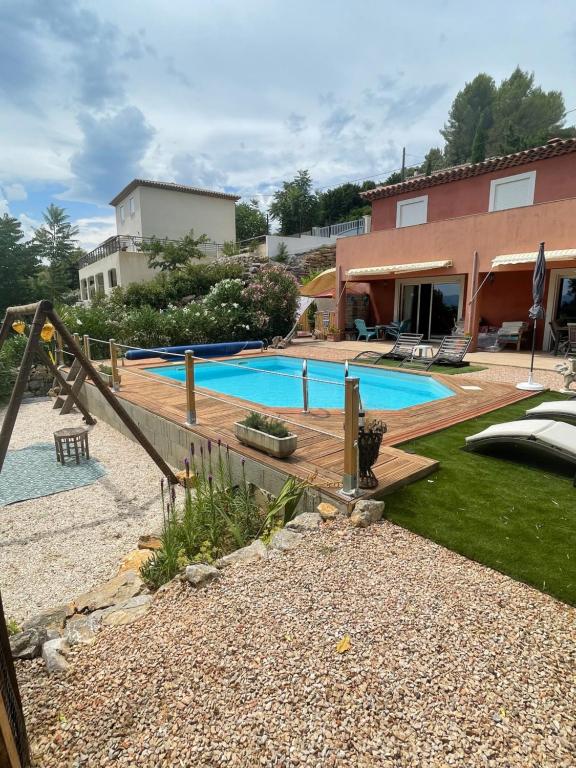a backyard with a swimming pool and a house at Villa 3ch piscine vue dégagée in Taradeau