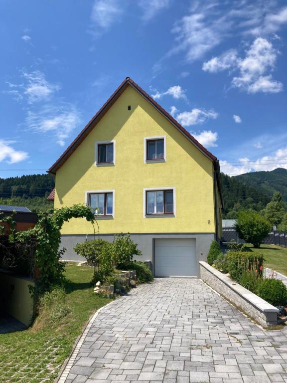 a yellow house with a driveway in front of it at Chill out Zone in Kraubath an der Mur