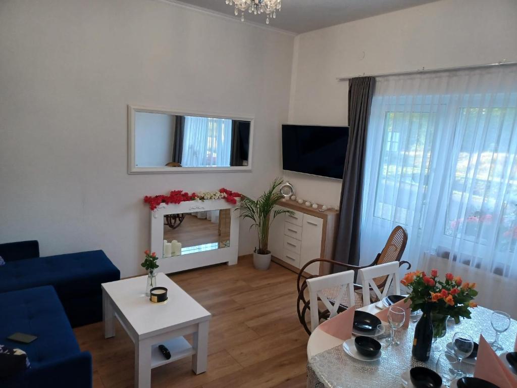 a living room with a blue couch and a table at Kaprys Apartament in Brenna