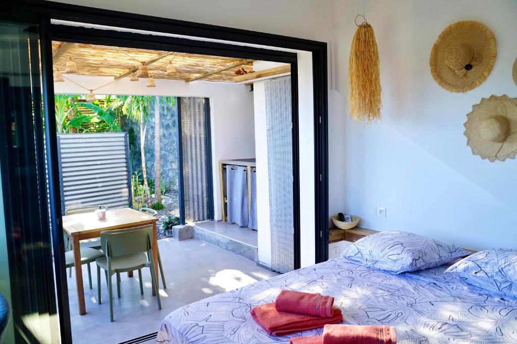 a bedroom with a bed and a table and a dining room at Lodge Palmiste, Escale tropicale in Étang-Salé