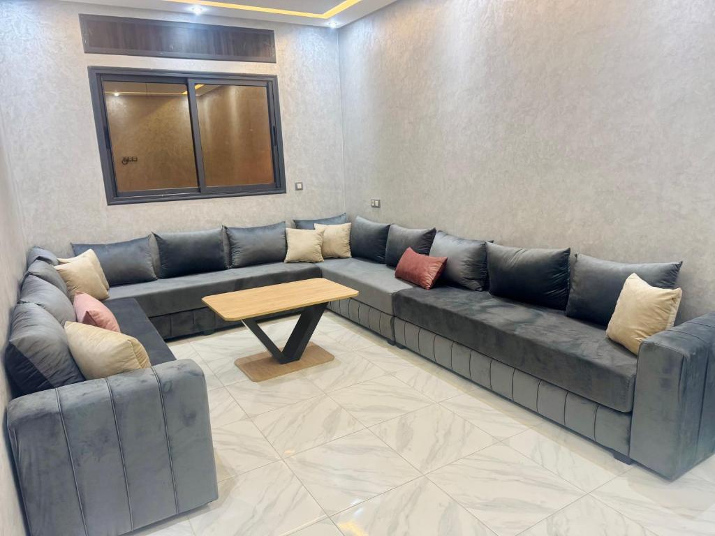 a living room with a blue couch and a table at حاضرة محيط in Jerifat