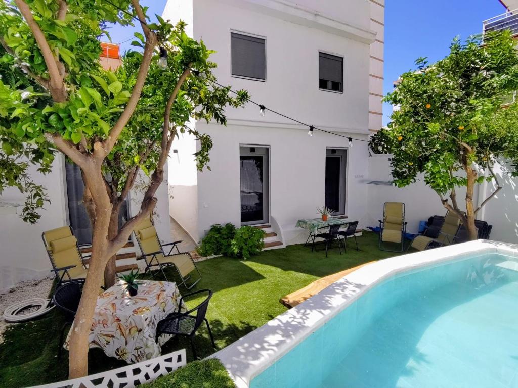 a backyard with a swimming pool and a house at CASITA NAIF ESTANCIAS EN TORRE DEL MAR a 30 METROS DE LA PLAYA in Torre del Mar