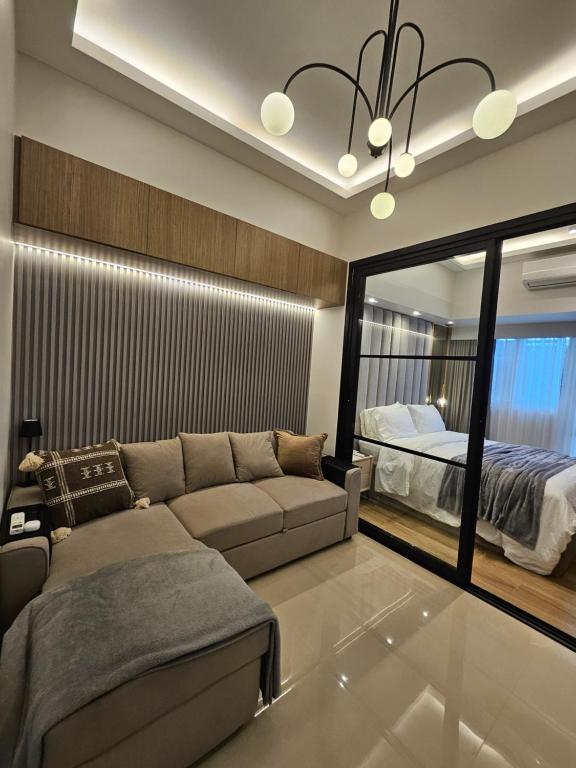 una sala de estar con un sofá y una cama en Luxury apartment at Park McKinley West suite 1, en Manila