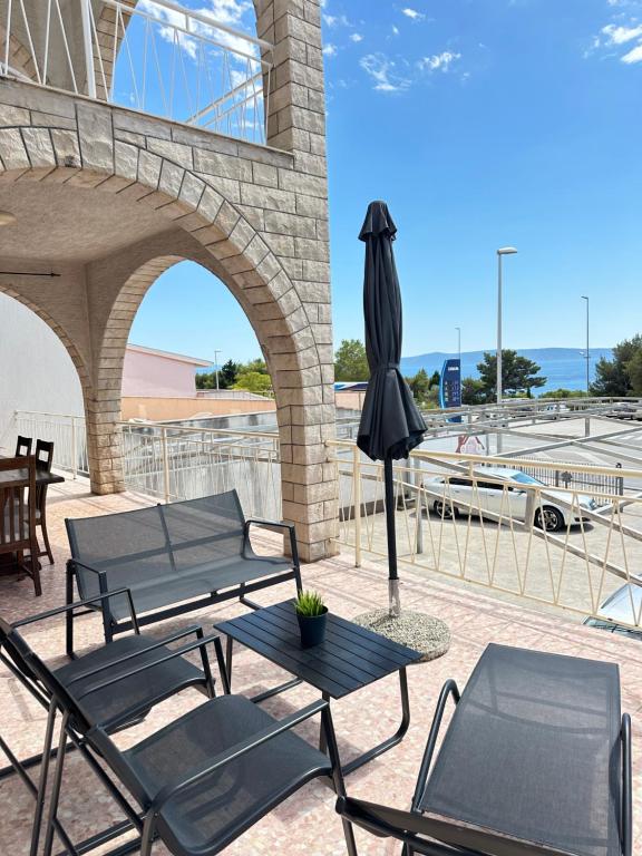 a patio with a table and chairs and an umbrella at Villa Mare in Makarska