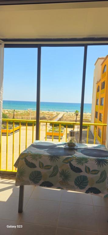a bedroom with a view of the beach from a balcony at appartement vue mer,accès direct plage,fibre,clim,parking public gratuit in Le Barcarès