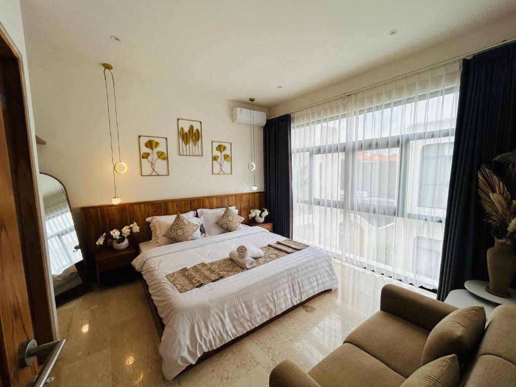 a bedroom with a bed and a large window at Nelayan Reef Apartment in Mantaak