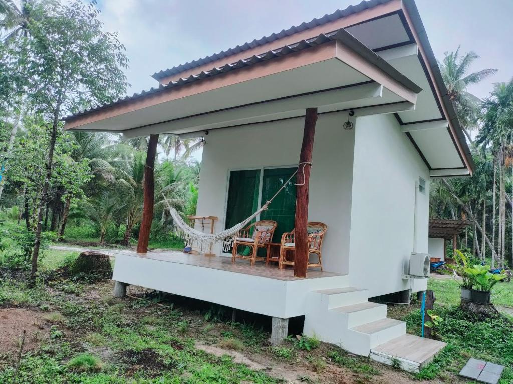 a small white house with a porch at Suanthara kokut in Ko Kood