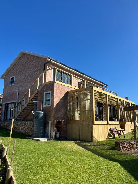 a large brick house with a staircase on it at Revival House Shalom in Jeffreys Bay