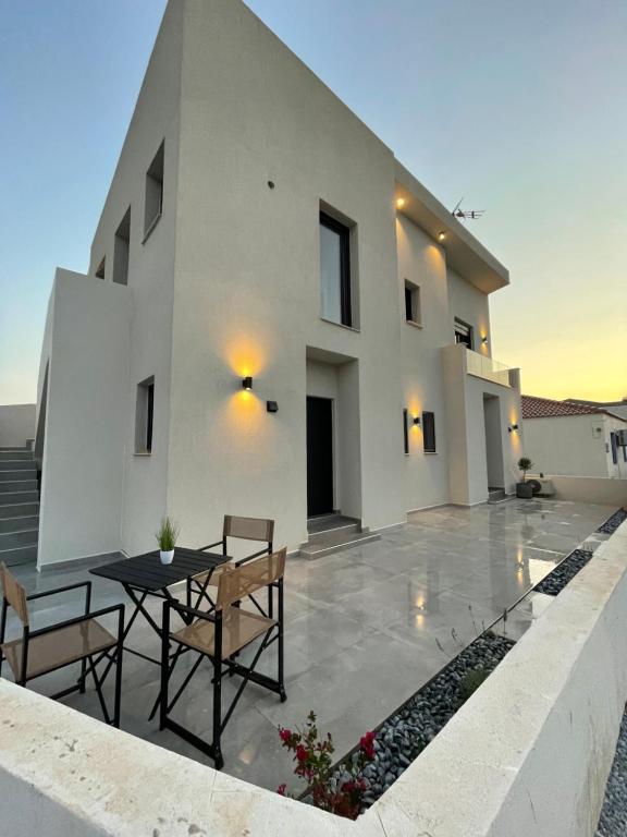 a patio with a table and chairs in front of a house at OLEA THASSOS Luxury Apartments in Skala Marion