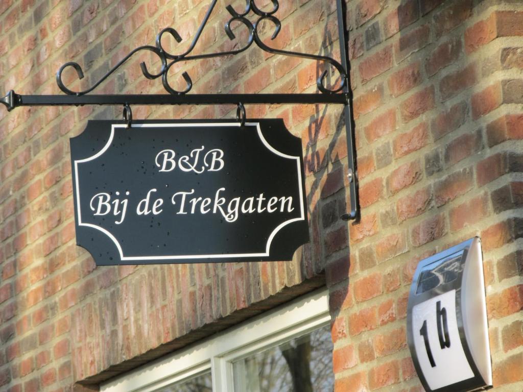 a sign hanging on the side of a brick building at Bed & Breakfast "Bij de Trekgaten", breakfast optioneel in Hollandscheveld