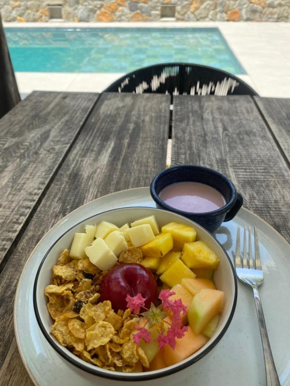 a bowl of food with fruit on a table at Hotel Boutique Albania in Otanche