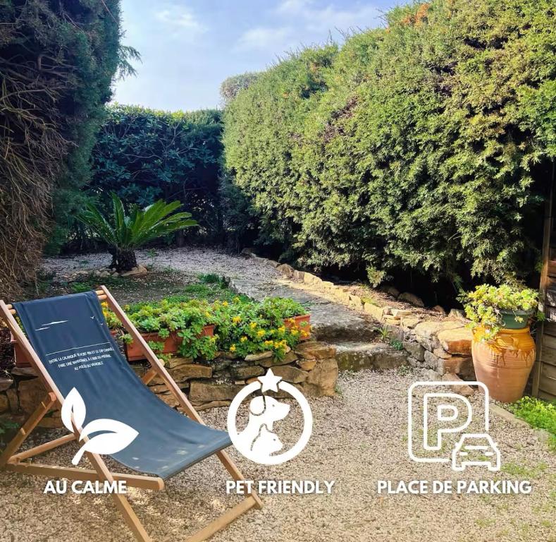 une chaise de jardin dans un jardin avec un panneau indiquant que tous les animaux de compagnie sont admis dans le jardin dans l'établissement Appartement Le Cocon Provencal - Parking Jardin Clim, à La Ciotat