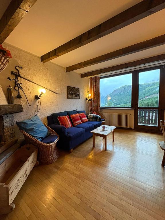 a living room with a blue couch and a table at Appartamento Vistabella in Livigno