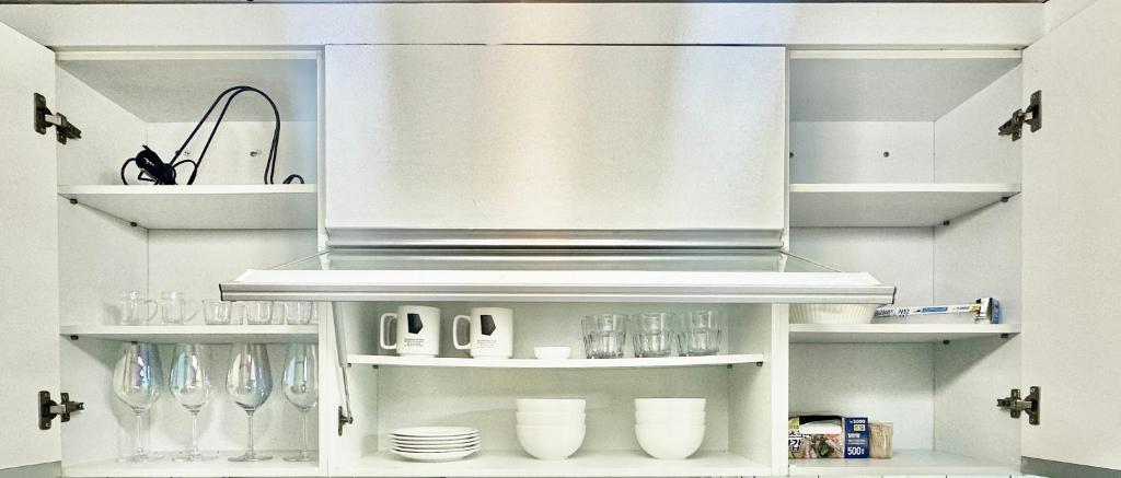 a kitchen with white shelves with glasses and utensils at Konkuk-SeongSu Goznuk Stay in Seoul
