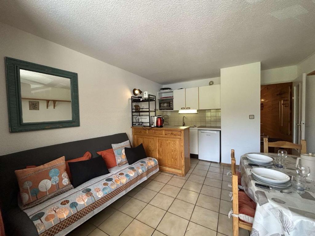 un salon avec un canapé et une cuisine dans l'établissement Appartement cosy 4/5 pers, centre Montgenèvre - FR-1-330D-72, à Montgenèvre
