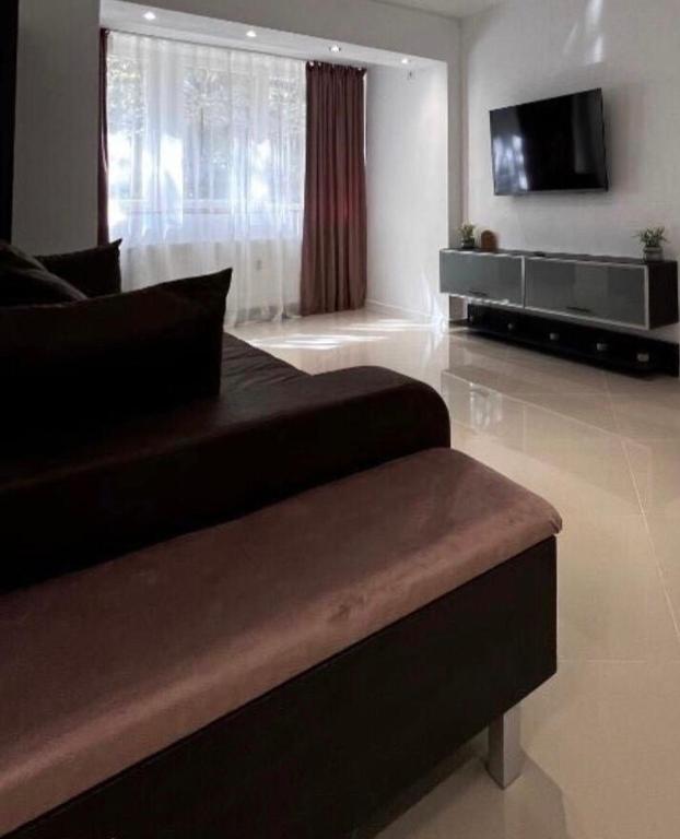 a living room with a couch and a flat screen tv at Cotroceni Prestigious in Bucharest