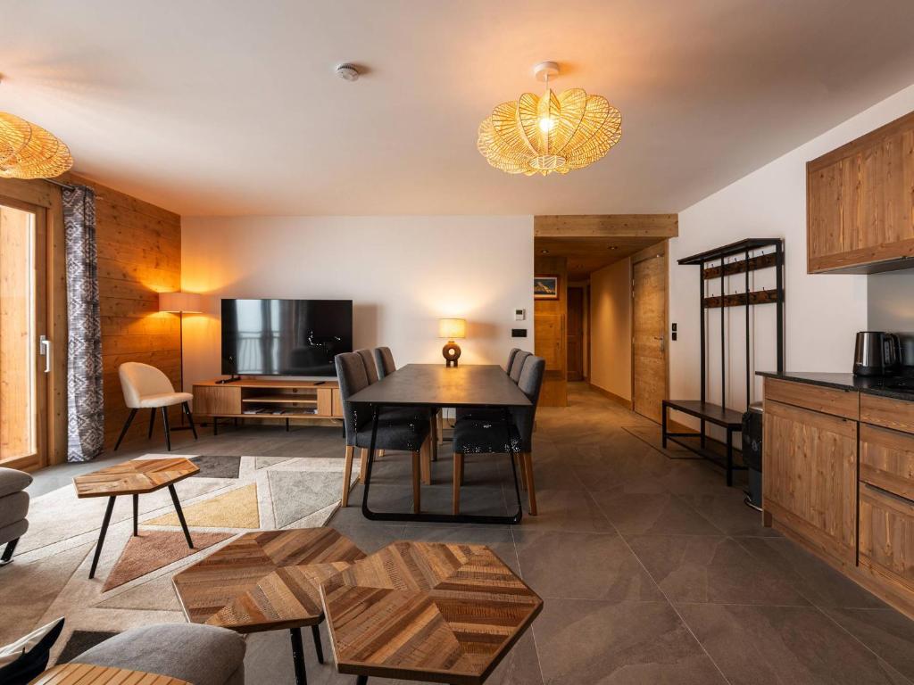 un salon avec une table et une télévision dans l'établissement Grand appart haut de gamme 8p, skis aux pieds, vue Mont Blanc, balcon, parking, linge inclus - FR-1-351-199, à La Plagne Tarentaise