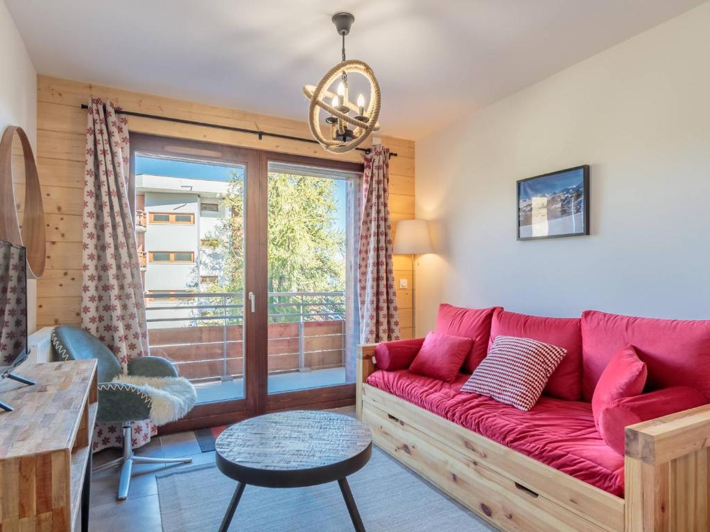 - un salon avec un canapé rouge et une fenêtre dans l'établissement Appartement 2 pièces avec balcon et garage à 100m des pistes - FR-1-351-215, à La Plagne Tarentaise