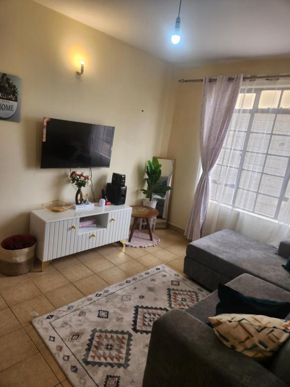a living room with a flat screen tv and a couch at Cozzyville in Machakos