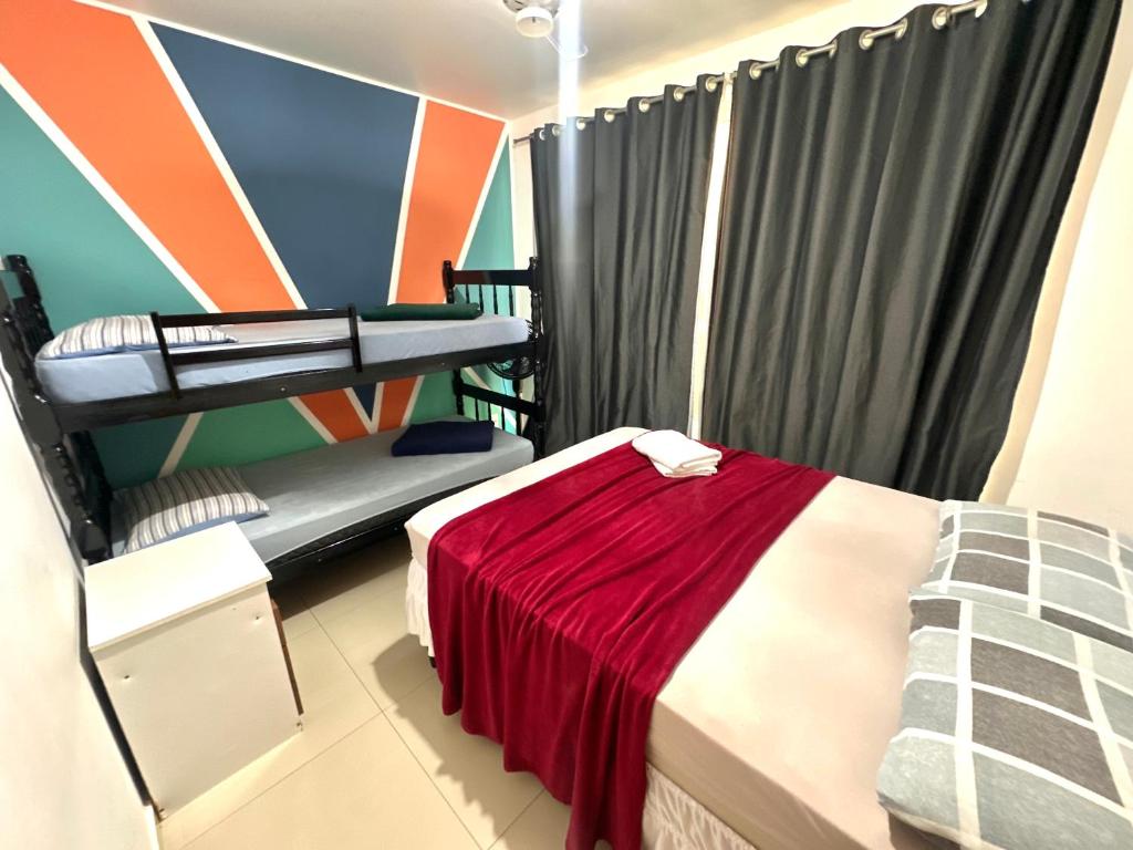 a room with a bed with a red blanket at Prainha - Apartamento 3 Quartos in Arraial do Cabo