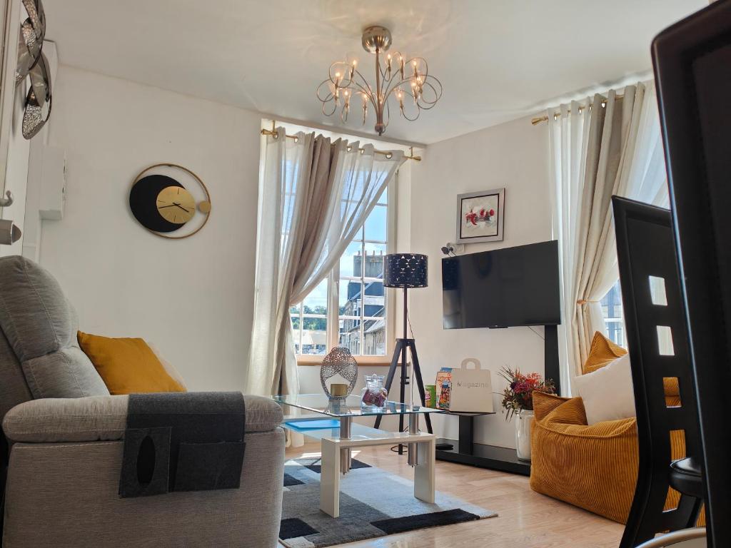 a living room with a couch and a table at L'Écrin Appart in Villedieu-les-Poêles