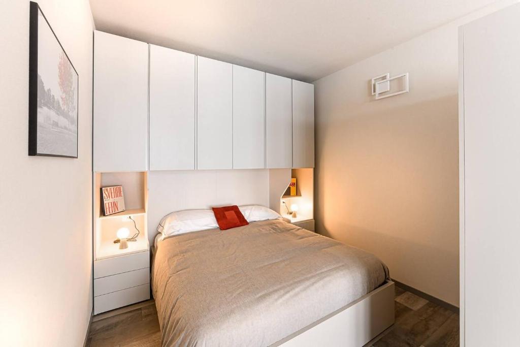 a small bedroom with a bed and white cabinets at Residenza Cavour - Appartamento A in Tirano