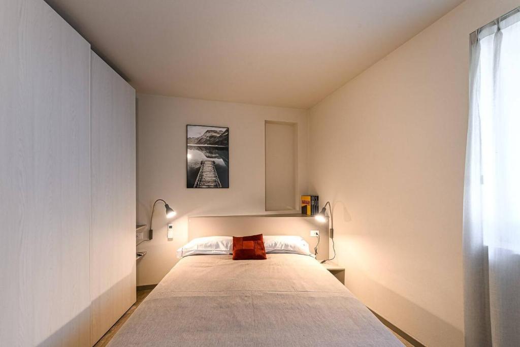 a bedroom with a large bed with two lamps at Residenza Cavour - Appartamento B in Tirano