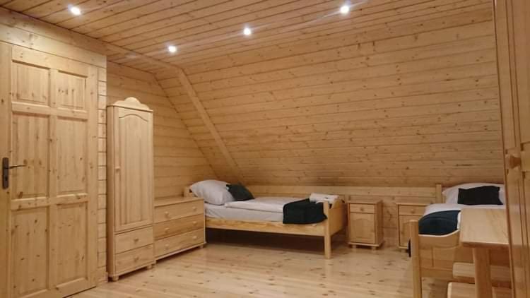 una stanza con due letti in una cabina di legno di Agroturystyka dzika łąka Słonów Domek 