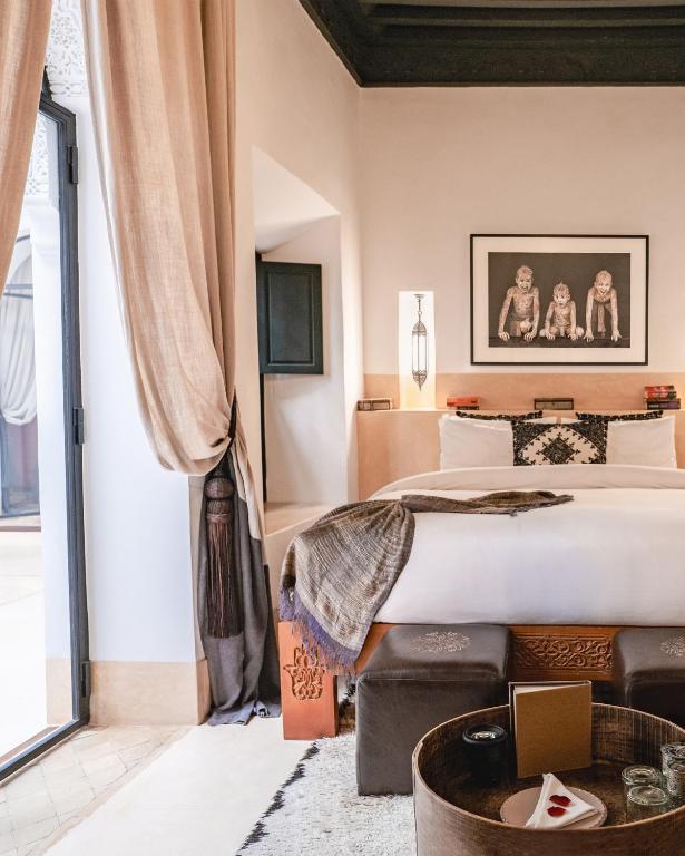 une chambre avec un grand lit et une grande fenêtre dans l'établissement Dar Assiya, à Marrakech