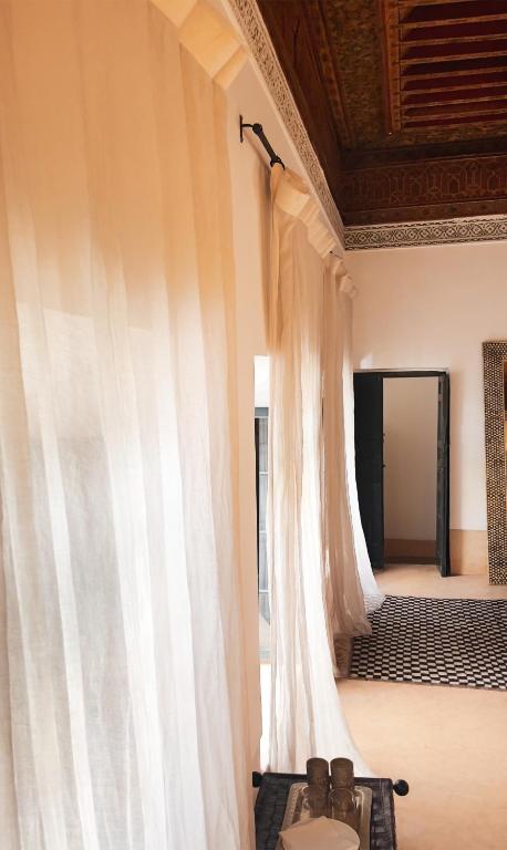 un rideau blanc suspendu dans une pièce avec une porte dans l'établissement Dar Assiya, à Marrakech