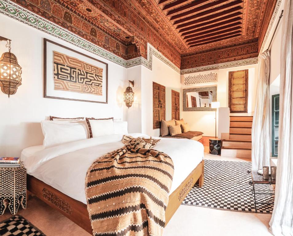 une chambre avec un grand lit avec un plafond en bois dans l'établissement Dar Assiya, à Marrakech