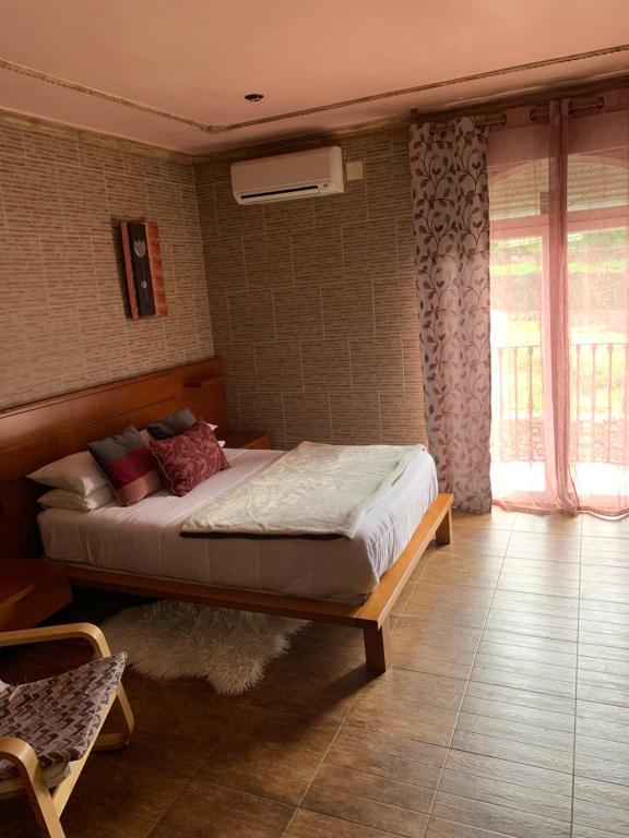 Casas del MonteにあるApartamento rural FRAGARIAの窓のある部屋にベッドがある寝室