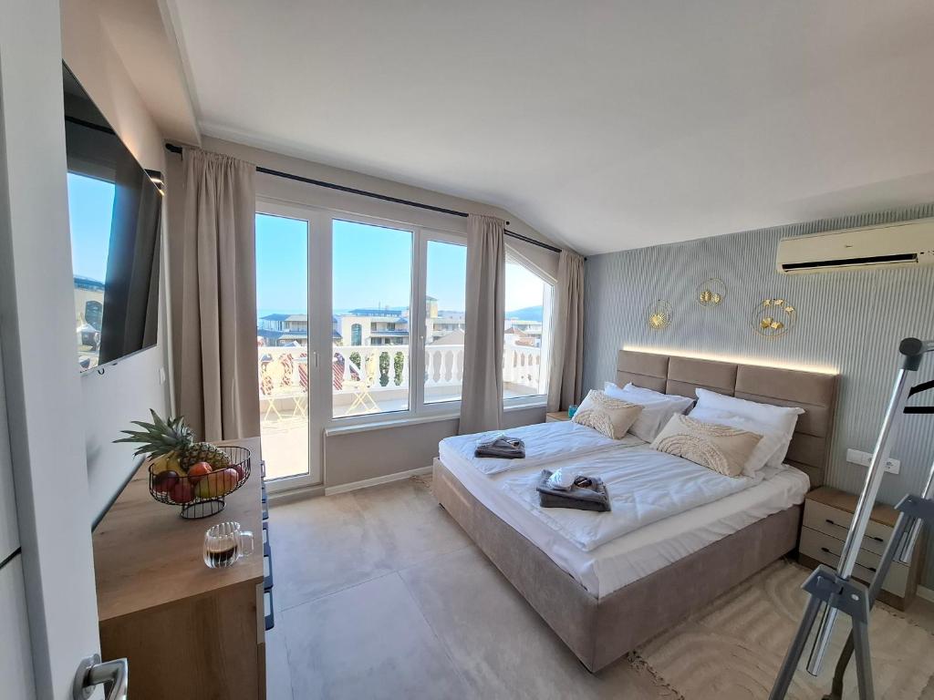 a bedroom with a large bed and a large window at Marina Elegance Apartments in Balchik