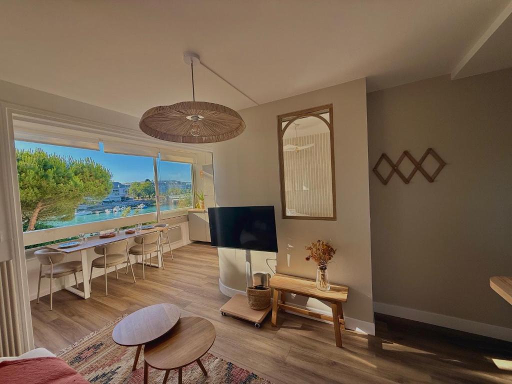 a living room with a table and a dining room at Appartement de Standing vue port in La Baule